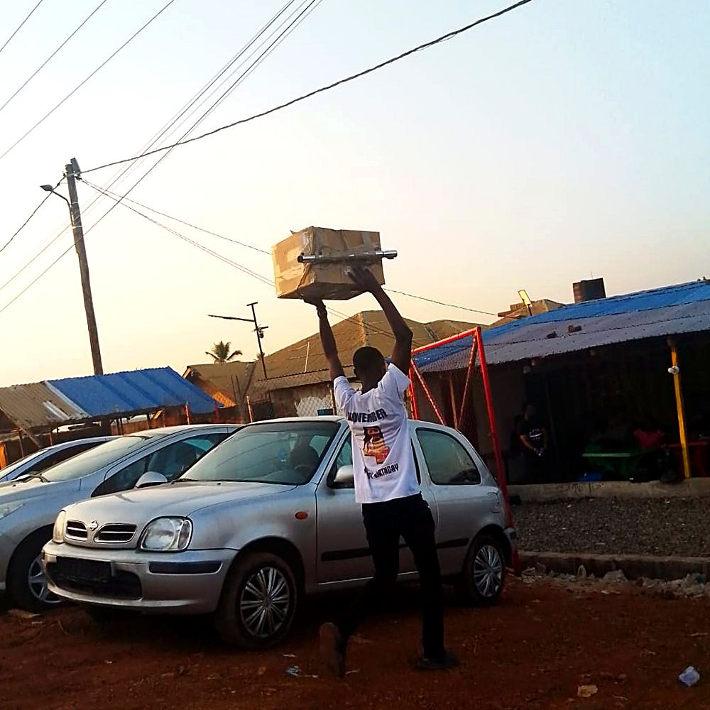 A man balances a donated box overhead at dusk